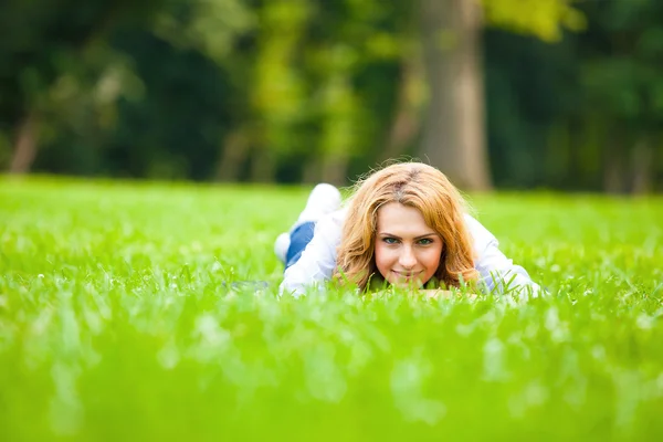 Sonriente rubia mujer en verde hierba mostrando amor — Foto de Stock