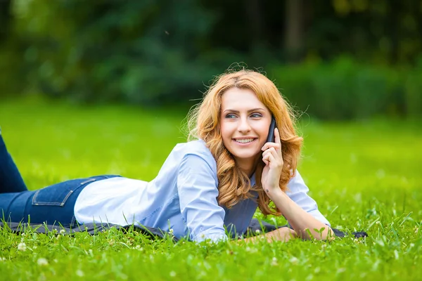 Mujer rubia hablando en el teléfono celular en hierba verde —  Fotos de Stock