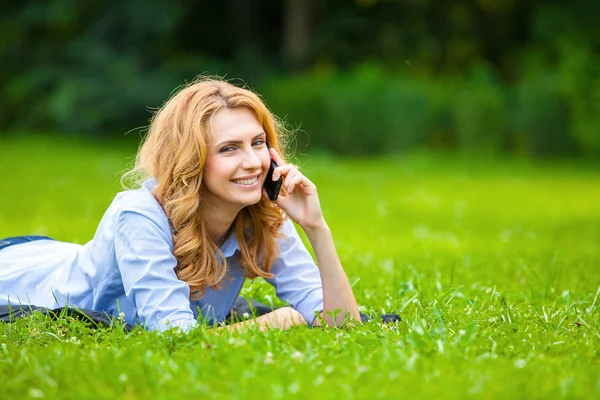 Mujer rubia hablando en el teléfono celular en hierba verde — Foto de Stock