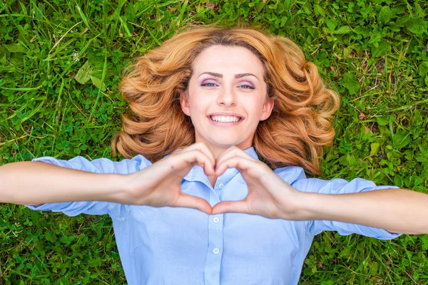 Beautiful young woman relaxing in grass — Stock Photo, Image