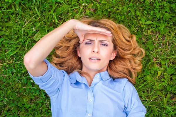 Beautiful young woman relaxing in grass — Stock Photo, Image