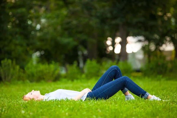 Mooie jonge vrouw ontspannen in gras — Stockfoto