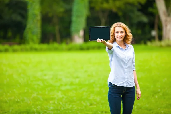 Tânără doamnă cu tabletă în parc — Fotografie, imagine de stoc