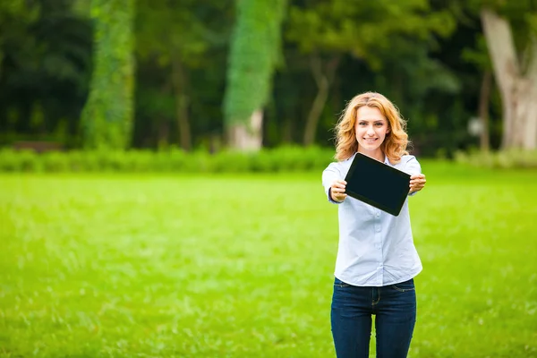 Молодая леди с планшетом в парке — стоковое фото