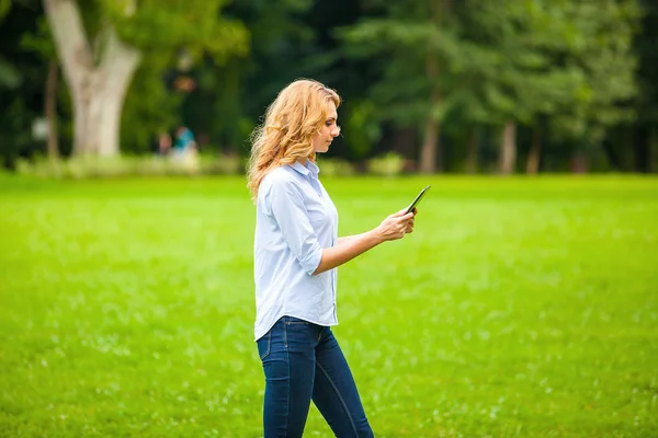 Joven dama con tableta en el parque — Foto de Stock