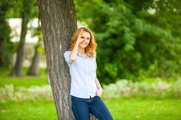 Belle jeune femme debout à côté d'un arbre — Photo