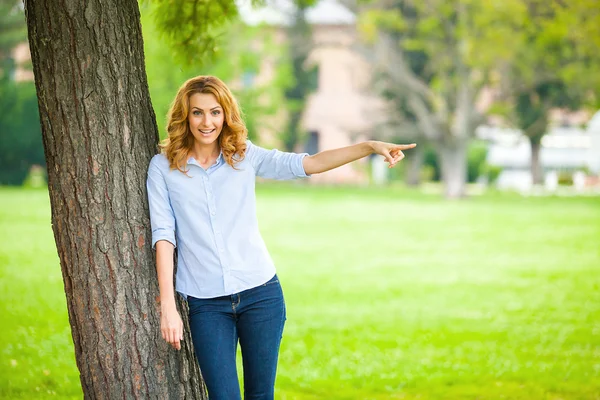 Hermosa joven de pie junto a un árbol —  Fotos de Stock