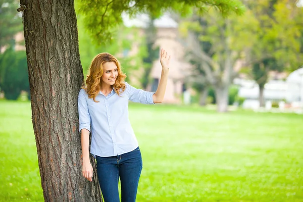 Hermosa joven de pie junto a un árbol —  Fotos de Stock