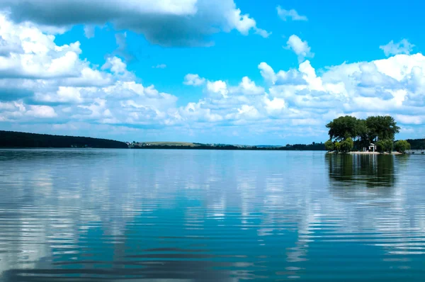 A big lake with small island and blue sky on a backgound — Stock Photo, Image
