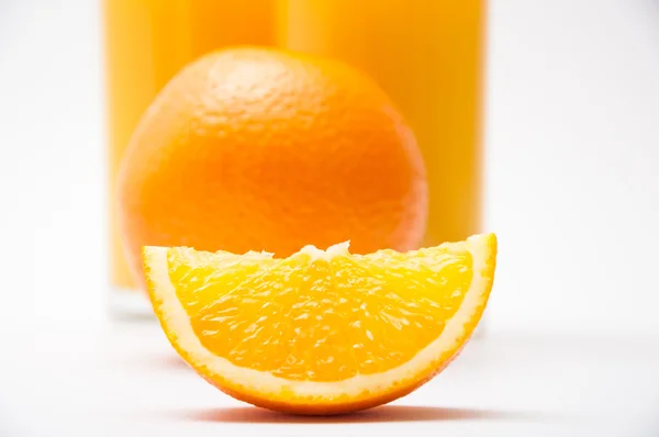 Orange, tranche et un verre de jus sur un fond — Photo