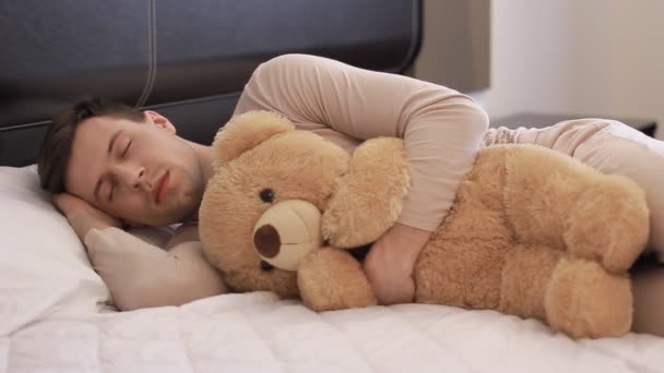 Guy is sleeping with teddy bear — Stock Video