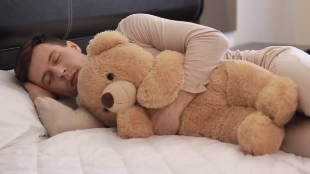 Guy is slapen met teddy bear — Stockvideo