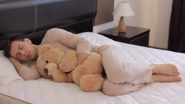 Guy is sleeping with teddy bear — Stock Video