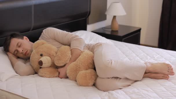 Adam oyuncak ayı ile uyuyor — Stok video