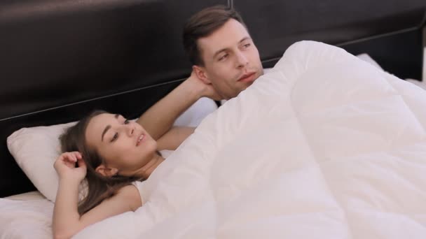 Ragazzo e una ragazza stanno guardando la TV in un letto — Video Stock