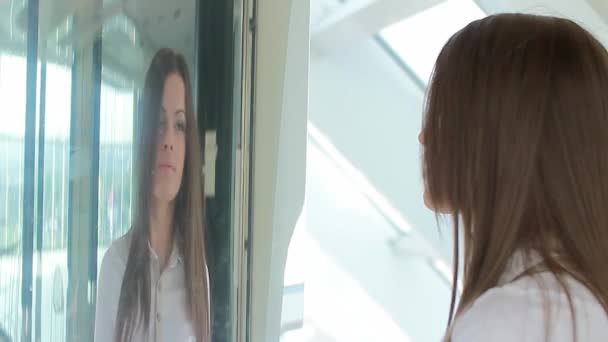 Woman checking her face in the mirror — Stock Video