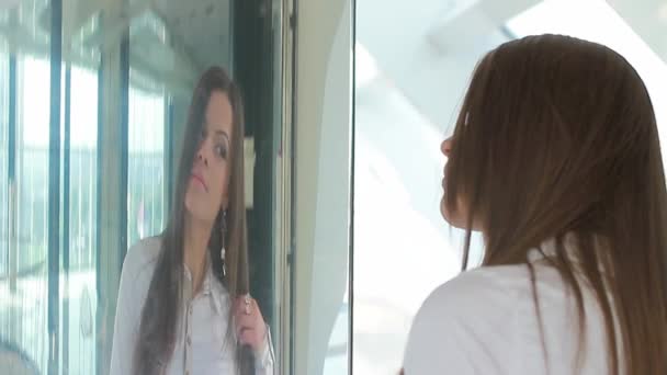 Mujer mirando su cara en el espejo — Vídeo de stock