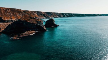 Rocks off the ocean coast line with turquoise water and dramatic cliffs Aerial view