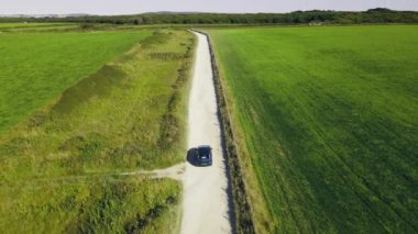 The car is moving on a sandy country road. Slow motion .