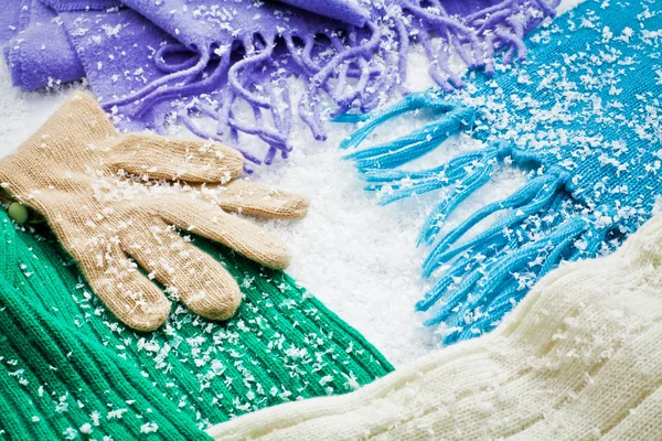 Gloves and scarves of wool over the snow — Stock Photo, Image