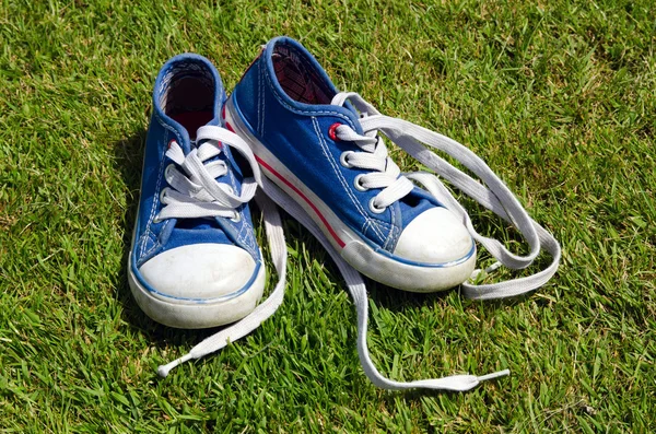 Zapatillas de deporte para niños viejos sobre fondo de hierba — Foto de Stock