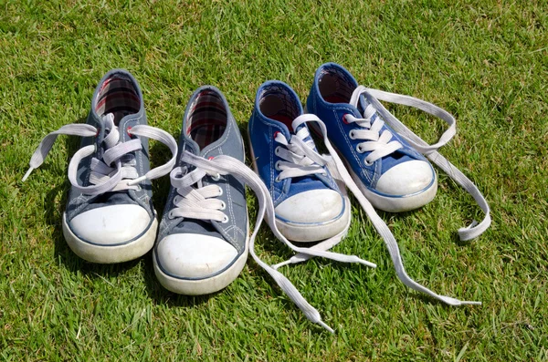 Twee paren van oude sneakers op gras achtergrond — Stockfoto