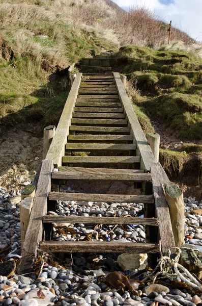 Holztreppen führen hinunter zu einem Kiesstrand — Stockfoto