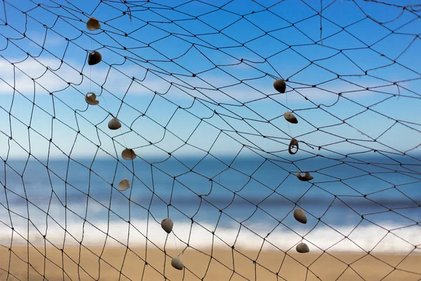 Рыболовные сети на пляже, море и небо на заднем плане — стоковое фото