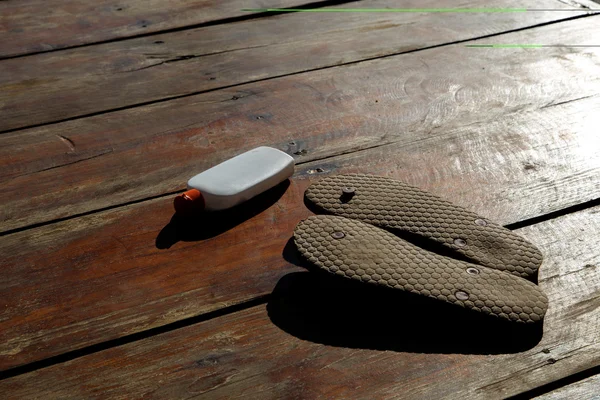 Suntan lotion and flip-flops — Stock Photo, Image