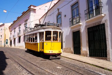 Lizbon 'da insanların olduğu caddenin ortasında klasik sarı tramvay. Portekiz
