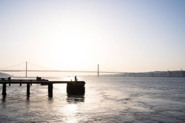 Lizbon 'da gün batımında nehrin önünde bir adamın fotokopi uzayı. Portekiz