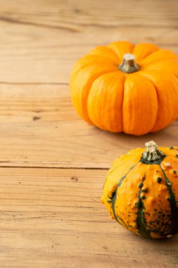 Tahta masadaki iki turuncu balkabağının üst görüntüsü, dikey, kopyalama alanı ile