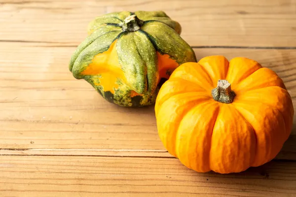 Primer Plano Dos Calabazas Naranjas Verdes Sobre Mesa Rústica Madera Fotos De Stock