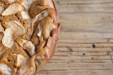 Tahta masa üzerinde yarım elmalı turtanın havadan görünüşü, seçici odak, yatay, kopyalama alanı ile