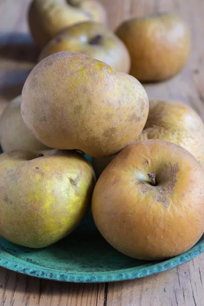 Yeşil tabakta yeşil elmaların üst görüntüsü tahta masada, seçici odak, dikey