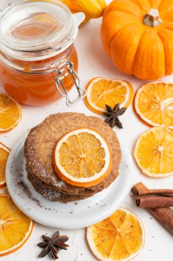 Portakal dilimli, tarçınlı, reçelli, yıldız anasonlu ve balkabaklı, seçici odak noktası beyaz masa, dikey