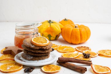 Turuncu dilimli kurabiyelerin üst görüntüsü, tarçın, reçel, yıldız anason ve balkabağı, seçici odak, beyaz masa, yatay