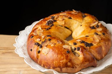 Yuvarlak çikolatalı brioche 'nin üst görüntüsü ahşap masa üzerinde, siyah arkaplan, yatay, kopyalama alanı ile