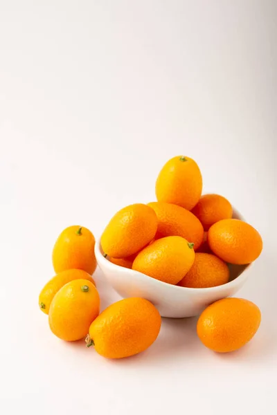 Vista Superior Kumquats Tazón Blanco Enfoque Selectivo Fondo Blanco Vertical — Foto de Stock