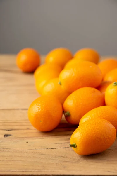 Nahaufnahme Einer Gruppe Kumquats Auf Einem Rustikalen Holztisch Grauer Hintergrund — Stockfoto