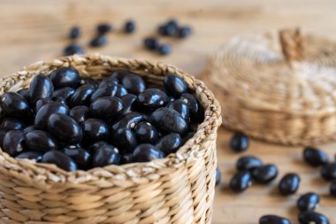 Kırsal ahşap masa üzerinde siyah fasulyeli sepetin yakın plan, seçici odak, yatay, kopyalama alanı olan