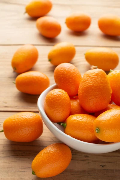 Luchtfoto Van Hele Kumquats Witte Schaal Houten Tafel Selectieve Focus — Stockfoto