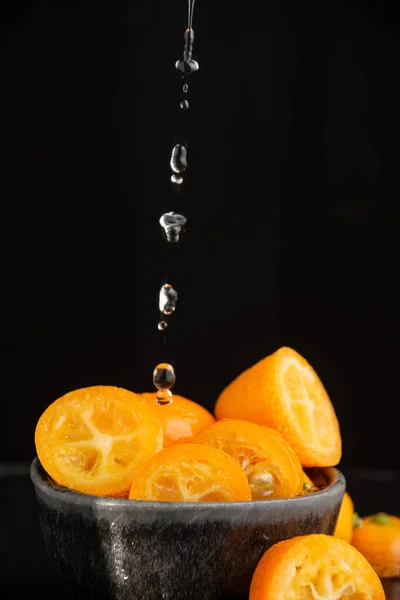 Close Cut Kumquats Water Drops Falling Selective Focus Black Background — Stockfoto