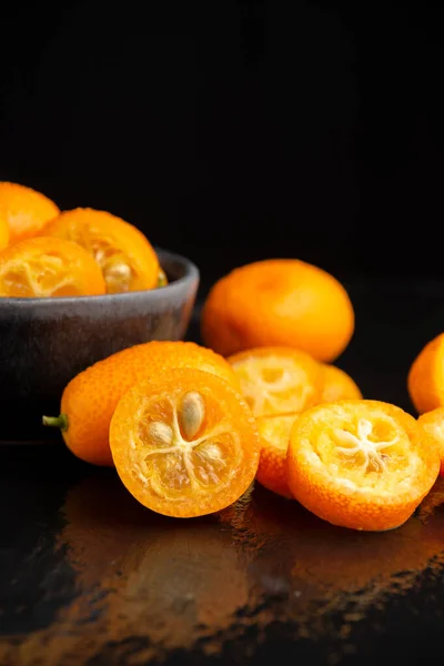 Close Sliced Orange Kumquats Wet Black Table Selective Focus Black — Stockfoto