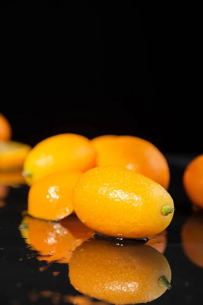 Nahaufnahme Von Nassen Kumquats Auf Nassem Schwarzen Tisch Mit Reflexion — Stockfoto