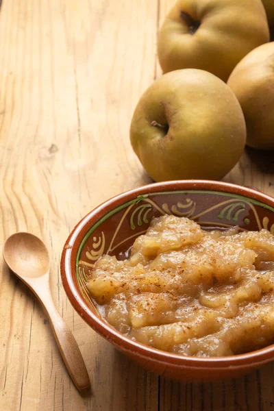 Üzerinde elma püresi ve kaşık olan bir masanın üstündeki kırsal kasenin üst görüntüsü, dikey olarak, kopyalama alanı ile.