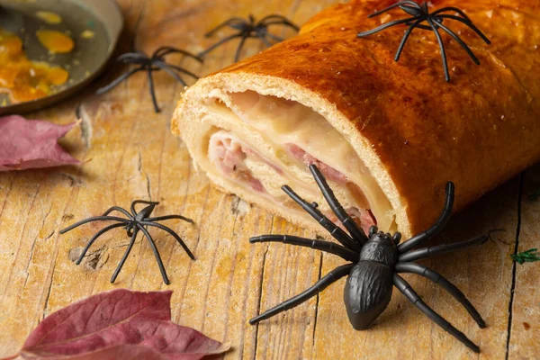 用塑料蜘蛛在木制桌子上烤火腿面包的特写 有选择地聚焦 水平的 图库图片