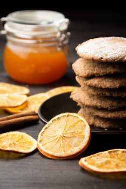 Arka planda portakal dilimleri ve reçel kavanozu olan, seçici odaklı, dikey