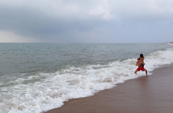 Chicos saltando sobre las olas — Foto de Stock
