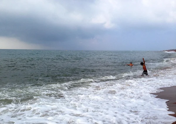 Chicos saltando sobre las olas — Foto de Stock